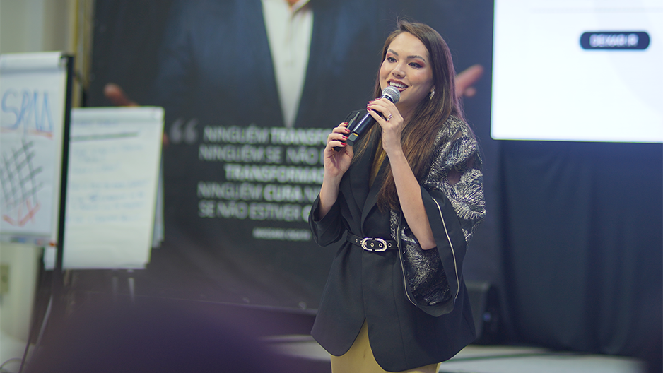 Bianca Ogata conduzindo apresentação no evento IFT