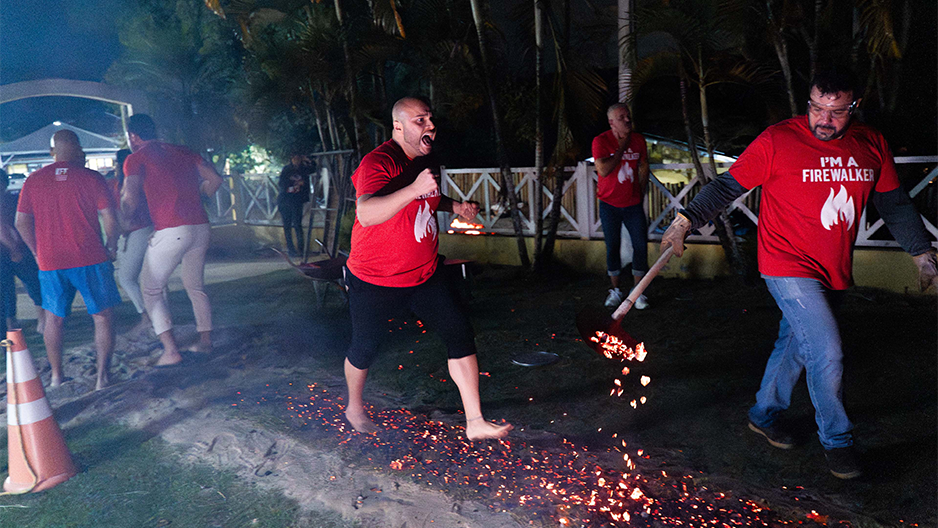 Participante em dinâmica de firewalking no evento IFT